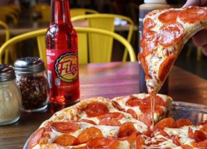 glass soda bottle and pepperoni pizza